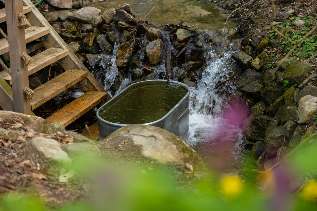a bucket full of water next to a waterfall